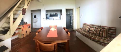 a living room with a wooden table and a couch at Duplex Morro de São Paulo in Cairu