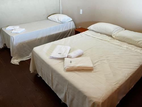 two beds in a room with towels on them at Duplex Morro de São Paulo in Cairu