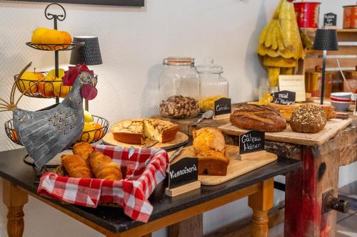 een tafel met verschillende soorten brood en gebak bij Le Fin Chapon in Excideuil