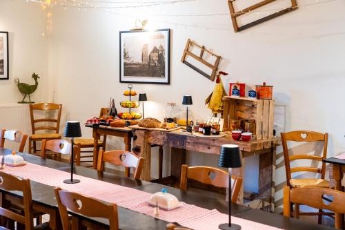 een eetkamer met tafels en stoelen en een aanrecht bij Le Fin Chapon in Excideuil