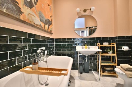 a bathroom with a tub and a sink and a mirror at 1 Purfleet Quay in King's Lynn