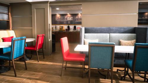 a restaurant with red and blue chairs and tables at Hampton Inn and Suites Houston-Katy in Katy