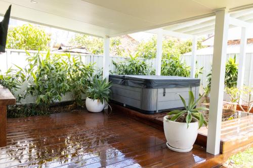 a hot tub on a porch with potted plants at Studio11 - Vincentia in Vincentia