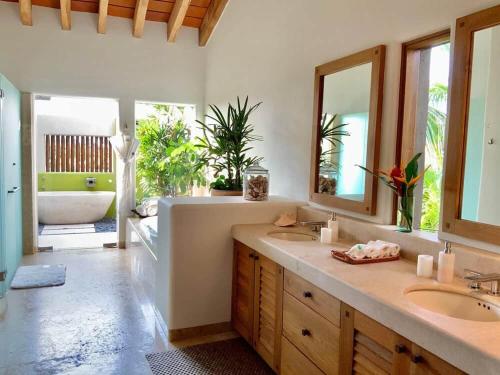 a bathroom with a tub and two sinks and a mirror at Lagos Del Mar - Casa Dos Vistas in Punta Mita