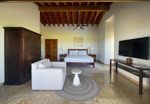 a living room with a bed and a television at Lagos Del Mar - Casa Dos Vistas in Punta Mita