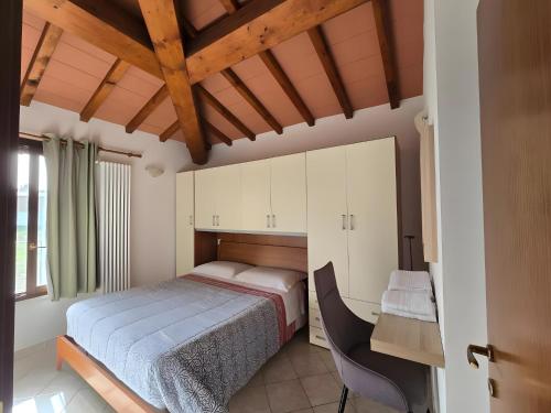 een slaapkamer met een bed, een bureau en een stoel bij Villette di Contignano in Contignano