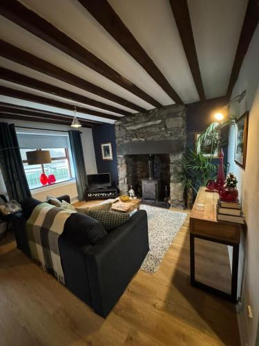 a living room with a couch and a fireplace at Snowdon Cottage in Llanberis