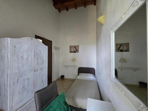 een slaapkamer met een bed en een grote spiegel bij Villette di Contignano in Contignano