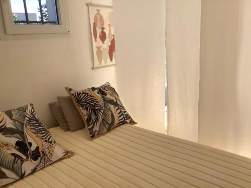 una camera da letto con un letto con due cuscini sopra di Location Studio de charme a Antibes