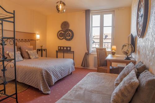 een slaapkamer met twee bedden, een bureau en een raam bij Le Fin Chapon in Excideuil