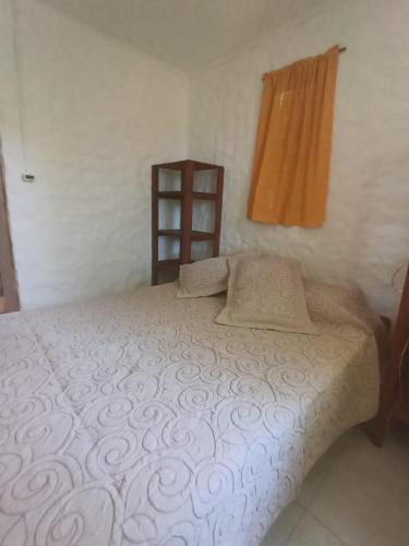 a bedroom with a bed and a wooden shelf at Casa de Amelia (Punta Rubia) in La Pedrera