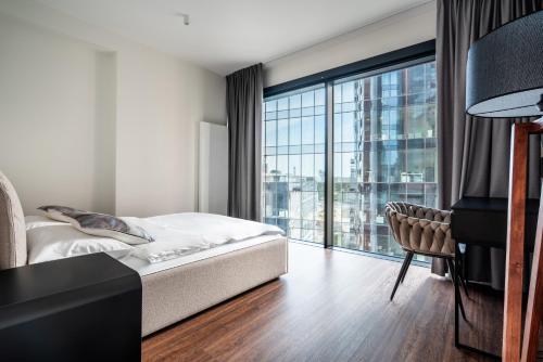 a bedroom with a bed and a large window at Towarowa Towers SkyLine in Warsaw