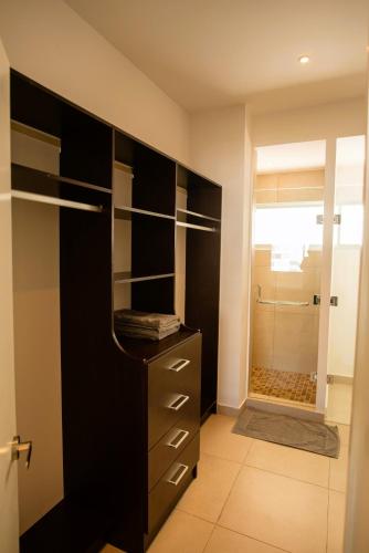 a bathroom with a black cabinet and a glass shower at Cozy, elegant 2BR Via Montejo, steps to US Consulate in Mérida