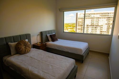 een hotelkamer met twee bedden en een raam bij Cozy, elegant 2BR steps to US Consulate in Xcumpich