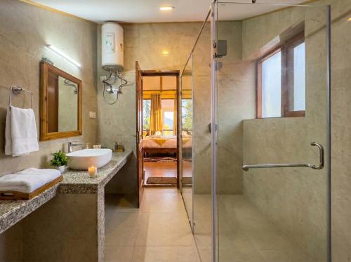 een badkamer met een douche en een wastafel bij The ForestBound Cottage in Manāli