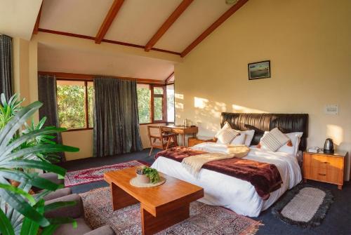 een slaapkamer met een groot bed en een tafel bij The ForestBound Cottage in Manāli