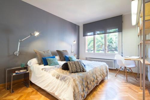 um quarto com uma cama com paredes azuis e uma secretária em Apartment Barcelona Rentals - Classic Bonanova Apartment em Barcelona