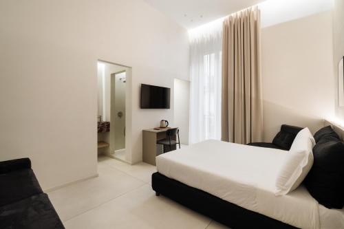 une chambre d'hôtel avec un lit et une télévision dans l'établissement Iodis Relais, à Naples