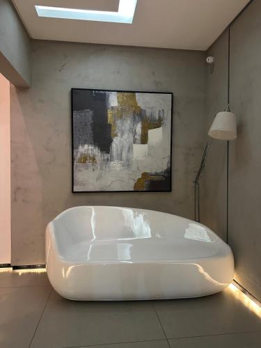 a white bath tub in a room with a painting at Studio On Mateus in Juiz de Fora