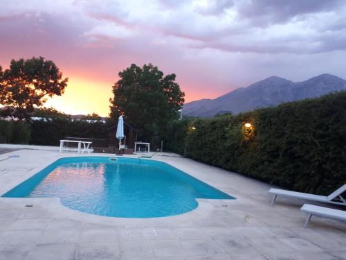 a swimming pool with a sunset in the background at La Terra di Gaia in Magliano deʼ Marsi