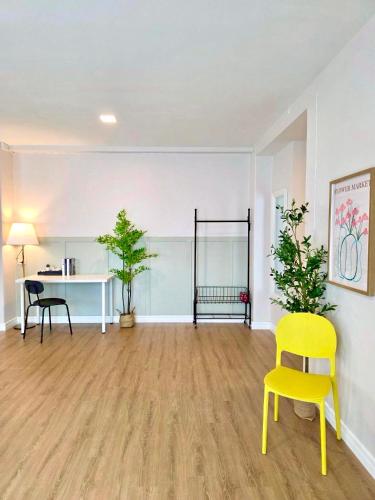 an empty room with a yellow chair and a desk at The See Stay Hatyai in Hat Yai