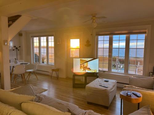 a living room with a couch and a tv in it at Seaside Cottage 180 Views in Petit-Etang