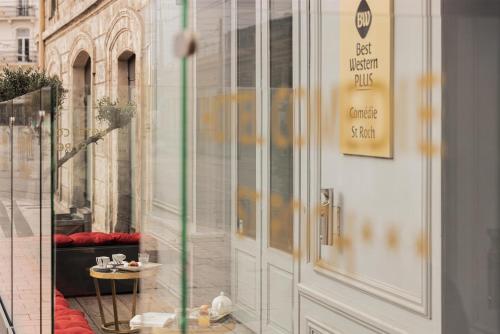 a glass door of a store with a table in front of it at Best Western Plus Comedie Saint Roch in Montpellier
