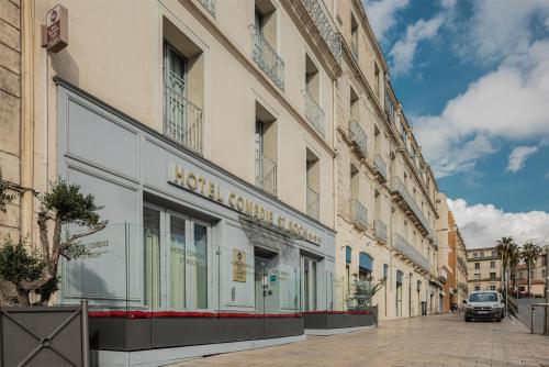 a building with a lot of windows on a street at Best Western Plus Comedie Saint Roch in Montpellier