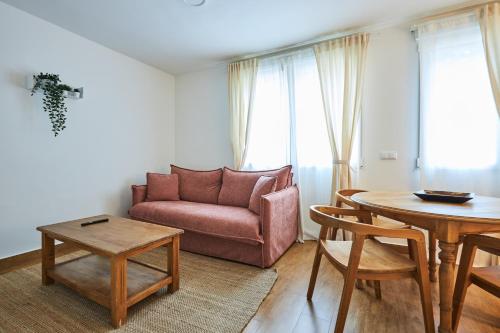 ein Wohnzimmer mit Sofa und Tisch in der Unterkunft El cuartel - Avila in Villatoro