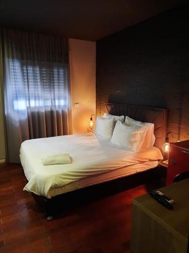 a bedroom with a large bed with white sheets and pillows at Beer Garden Hotel in Tel Aviv