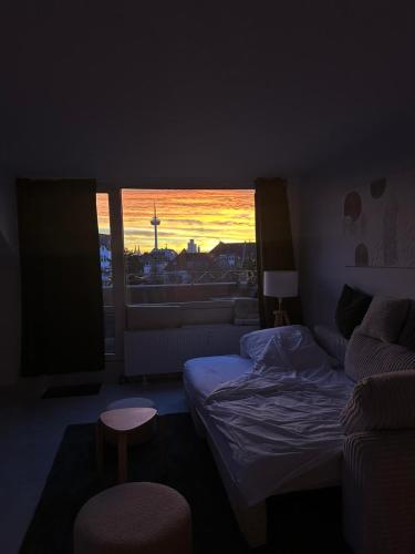 ein Schlafzimmer mit einem Bett und einem Fenster mit einem Sonnenuntergang in der Unterkunft Dom View Luxury Apartment in Köln
