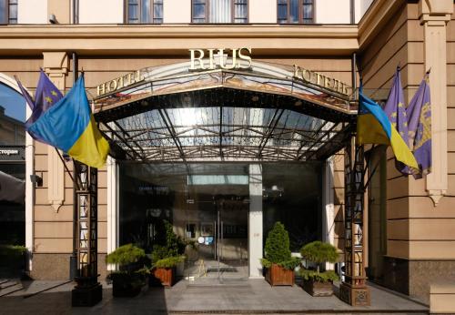 a entrance to a building with flags in front of it at Rius Hotel Lviv in Lviv