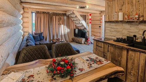 een woonkamer met een tafel in een blokhut bij Cabana de la Stână in Rîşnov