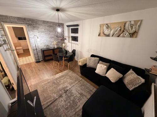 a living room with a black couch and a table at HRF Hackney Apartments in London
