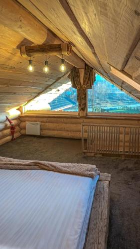 a large bed in a room with a large window at Cabana de la Stână in Râşnov