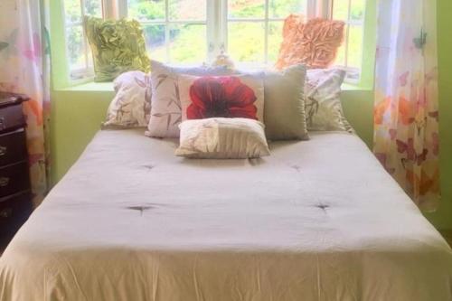 un lit avec des draps blancs et des oreillers dans une chambre dans l'établissement Bamboo - Sleeps 6 - Garden - Parking, à Bamboo