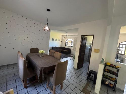 a dining room with a table and a living room at Casa de praia Silva Bráz in Serra