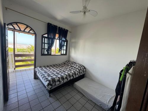 a small room with a bed and a window at Casa de praia Silva Bráz in Serra