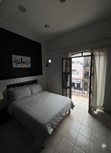 a bedroom with a bed and a large window at Departamento en el corazón de Zamora, a 2 cuadras del Santuario Guadalupano in Zamora de Hidalgo