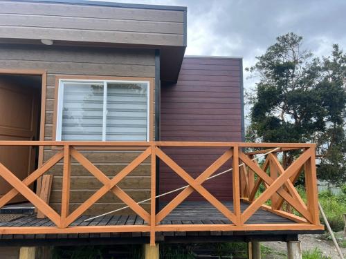 een huis met een houten terras ervoor bij CASA DEL CENTRo in Quellón