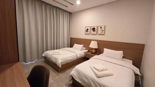 a hotel room with two beds and a chair at Maison 7 New Cairo in Cairo