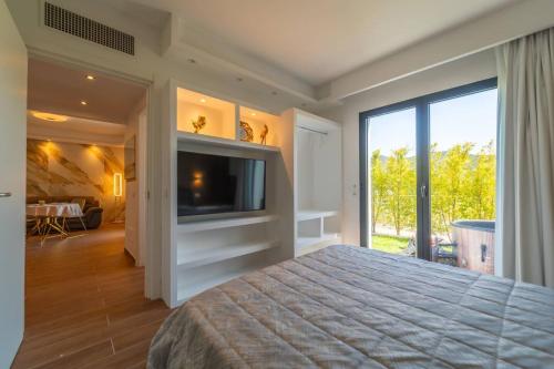 een slaapkamer met een groot bed en een televisie bij la maison dorée in Olbia