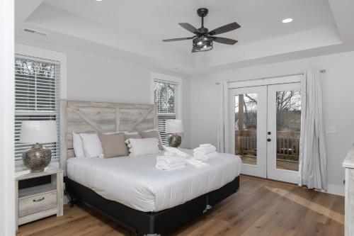 een witte slaapkamer met een bed en een plafondventilator bij Springfield Haven in Springfield