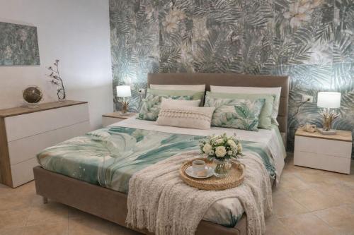 una camera da letto con un letto e un tavolo con fiori di Le Stanze Della Castellana a Bosa