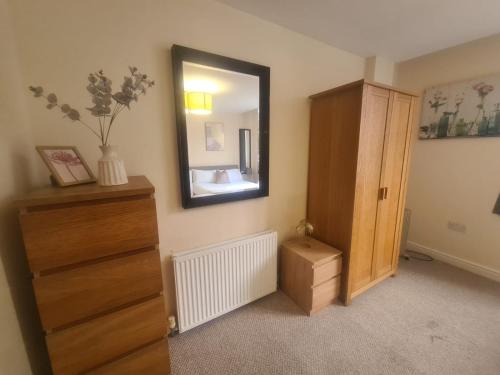 a bedroom with a dresser and a mirror at West Park One Bedroom in South Shields