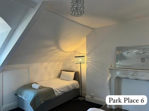 a small room with a bed and a lamp at Park Place Apartments in Sunderland