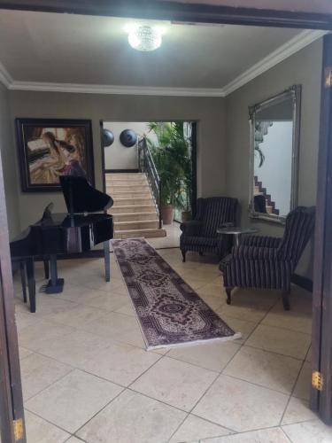 a living room with a piano and a rug at MiCasa Hartbeespoort in Hartbeespoort