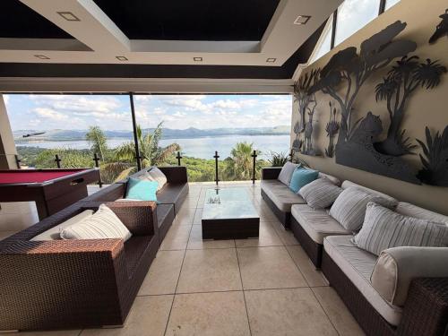 een woonkamer met banken en uitzicht op de oceaan bij Mi Casa in Hartbeespoort