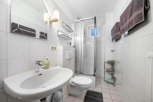 Ferienwohnung Dommel في كوكسهافن: حمام أبيض مع حوض ومرحاض