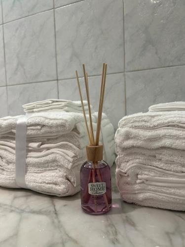 a bottle with sticks in it next to towels at La Maison in Mestre